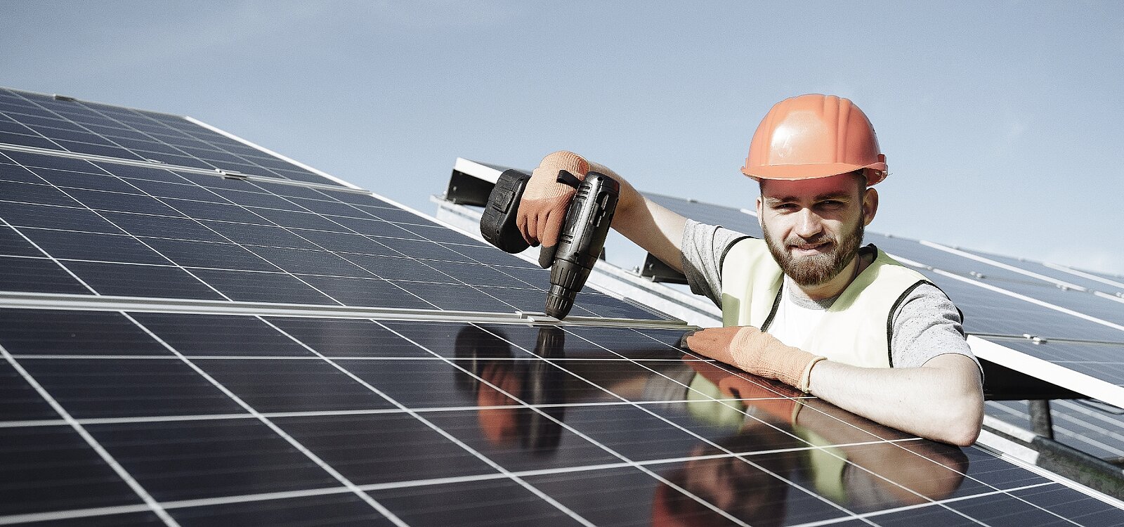Abbildung: Junger Handwerker bei der Montage von Solarpanels
